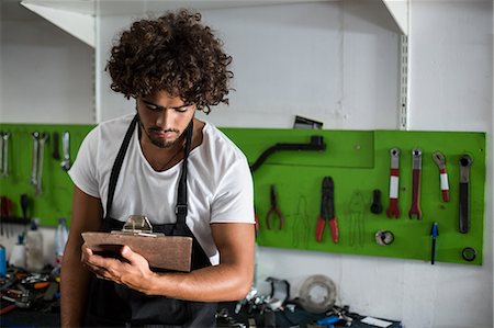 simsearch:6109-08537278,k - Bike mechanic holding clipboard Stock Photo - Premium Royalty-Free, Code: 6109-08537213