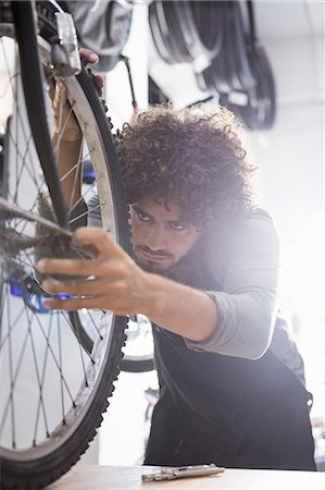 simsearch:6109-08537332,k - Worker repairing bicycles Stock Photo - Premium Royalty-Free, Code: 6109-08537359