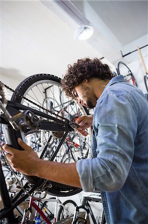 simsearch:6109-08537332,k - Worker repairing bicycles Stock Photo - Premium Royalty-Free, Code: 6109-08537370