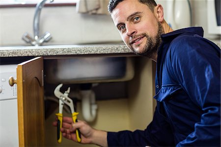 plumbing - Portrait of plumber repairing a sink Foto de stock - Sin royalties Premium, Código: 6109-08537497