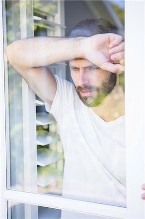simsearch:6109-07497398,k - Depressed man leaning his head on window glass Fotografie stock - Premium Royalty-Free, Codice: 6109-08537404