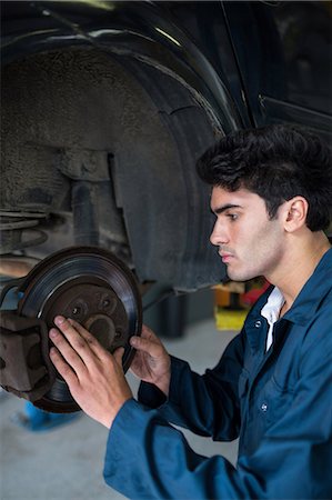 simsearch:6109-08537616,k - Mechanic examining car brake Stock Photo - Premium Royalty-Free, Code: 6109-08537596