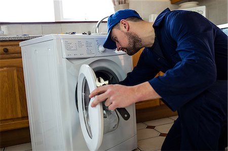 fixing - Handyman repairing a washing machine Stock Photo - Premium Royalty-Free, Code: 6109-08537510