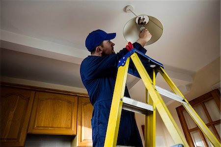 simsearch:6109-08536978,k - Electrician repairing a ceiling lamp Stock Photo - Premium Royalty-Free, Code: 6109-08537533