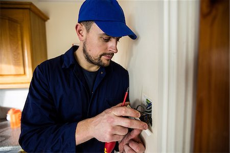 serviceman - Electrician fixing a door bell Photographie de stock - Premium Libres de Droits, Code: 6109-08537535