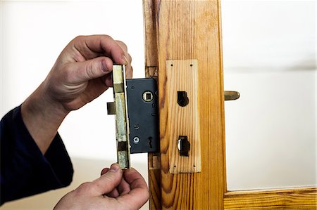 simsearch:6109-08537594,k - Mans hand fixing the door lock Foto de stock - Royalty Free Premium, Número: 6109-08537538