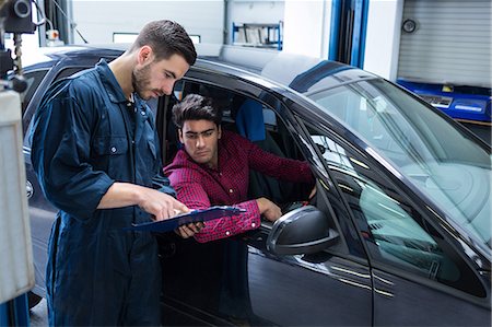 Mechanic showing the quotation to a customer Stock Photo - Premium Royalty-Free, Code: 6109-08537667