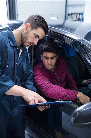 Mechanic showing the quotation to a customer Stock Photo - Premium Royalty-Free, Code: 6109-08537668