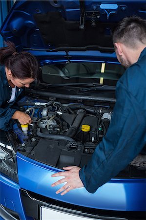 Team of mechanics examining car engine Foto de stock - Sin royalties Premium, Código: 6109-08537680