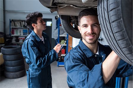 Mechanic fixing a wheel while a colleague preparing a check list Stockbilder - Premium RF Lizenzfrei, Bildnummer: 6109-08537755