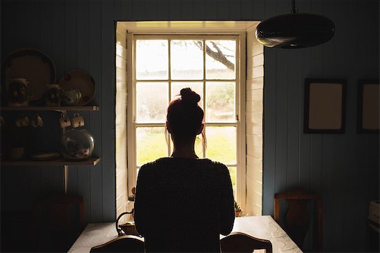 Woman standing in front of window Stock Photo - Premium Royalty-Free, Image code: 6109-08537766