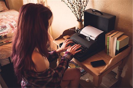 sitting at old fashioned desk - Young woman using typewriter Photographie de stock - Premium Libres de Droits, Code: 6109-08537785