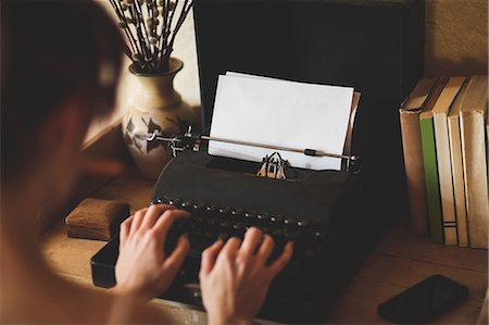 Young woman using typewriter Fotografie stock - Premium Royalty-Free, Codice: 6109-08537786