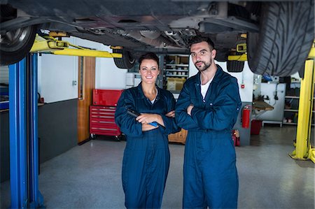 Mechanics with arms crossed standing under a car Stock Photo - Premium Royalty-Free, Code: 6109-08537702