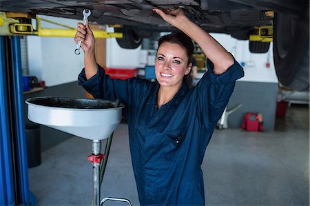 simsearch:6109-08537633,k - Female mechanic servicing a car Foto de stock - Sin royalties Premium, Código: 6109-08537712