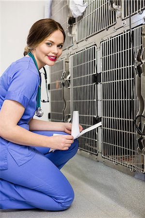 doctor kneeling - Portrait of vet monitoring sick rabbit in cage Stock Photo - Premium Royalty-Free, Code: 6109-08537855