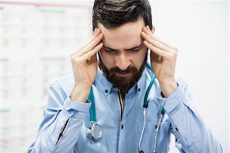 sad office man - Stressed vet sitting with hand on forehead Stock Photo - Premium Royalty-Free, Code: 6109-08537867