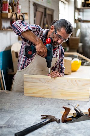 forage - Carpenter drilling a hole in a wooden plank Photographie de stock - Premium Libres de Droits, Code: 6109-08537943