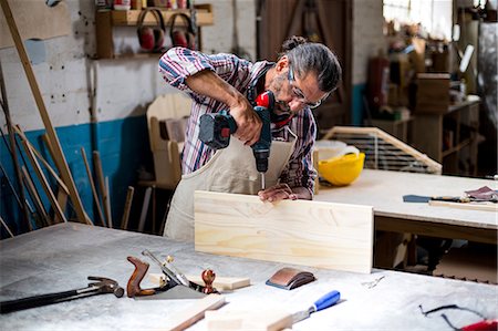 simsearch:6109-08536978,k - Carpenter drilling a hole in a wooden plank Stock Photo - Premium Royalty-Free, Code: 6109-08537942