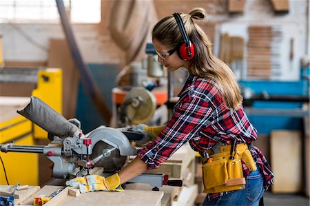 Female carpenter cutting wooden plank with electric saw Photographie de stock - Premium Libres de Droits, Code: 6109-08538051