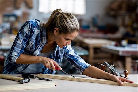 simsearch:6109-08538063,k - Female carpenter using chisel on wooden plank Foto de stock - Sin royalties Premium, Código: 6109-08538071