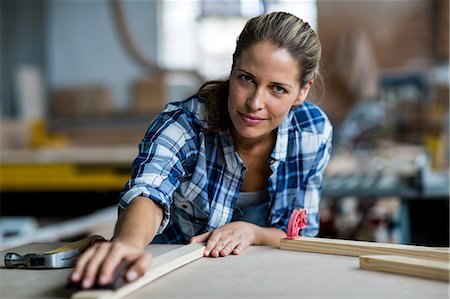 simsearch:6109-08538063,k - Female carpenter rubbing wooden plank with sanding block Foto de stock - Sin royalties Premium, Código: 6109-08538076