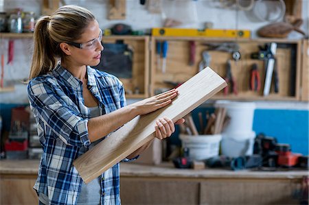 Female carpenter checking a wooden plank Stock Photo - Premium Royalty-Free, Code: 6109-08538083