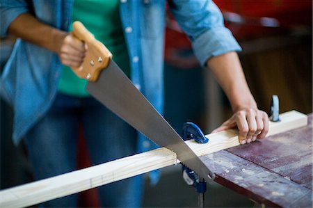 simsearch:400-05058869,k - Female carpenter cutting plank with hand saw Foto de stock - Royalty Free Premium, Número: 6109-08538092