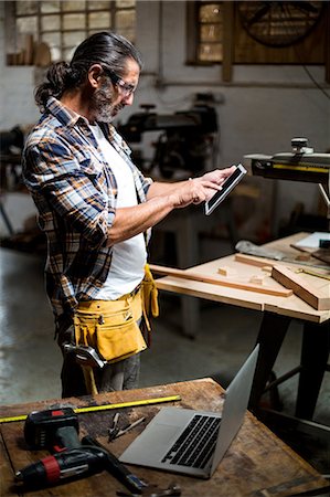Carpenter using digital tablet in workshop Foto de stock - Sin royalties Premium, Código: 6109-08538006