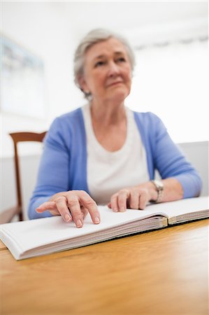 Blind senior woman using braille to read Stock Photo - Premium Royalty-Free, Code: 6109-08538193