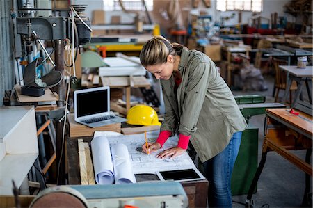 Female carpenter marking on blueprint Foto de stock - Sin royalties Premium, Código: 6109-08538108