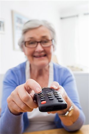 simsearch:6109-08538212,k - Senior woman holding a remote control Stock Photo - Premium Royalty-Free, Code: 6109-08538213