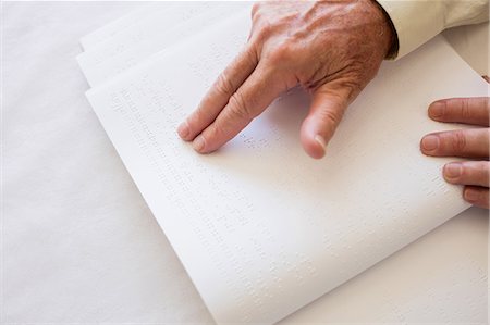 Blind senior woman using braille to read Stock Photo - Premium Royalty-Free, Code: 6109-08538363