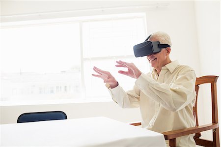 Senior man using an oculus rift Foto de stock - Sin royalties Premium, Código: 6109-08538371