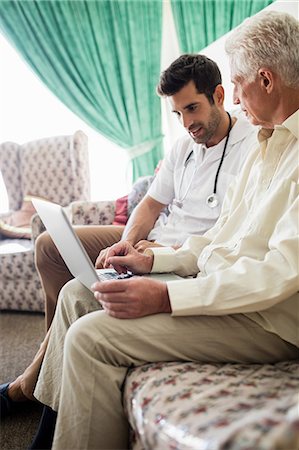 elderly person with caregiver at home - Nurse and senior man using laptop Foto de stock - Sin royalties Premium, Código: 6109-08538372