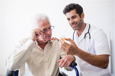 simsearch:6109-08689542,k - Nurse giving pills to senior man Stock Photo - Premium Royalty-Free, Code: 6109-08538336