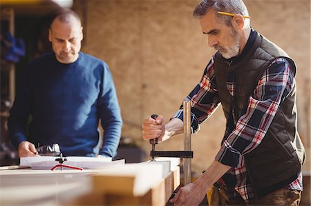 simsearch:6109-08689719,k - Carpenter fixing a plank of wood in carpentry Foto de stock - Royalty Free Premium, Número: 6109-08689560