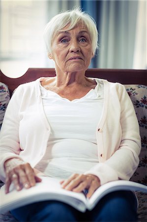 spielstand - Pensive blind woman sitting on sofa with braille book on lap Stockbilder - Premium RF Lizenzfrei, Bildnummer: 6109-08689503