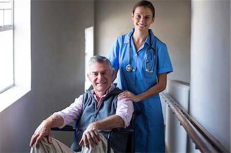 Portrait of smiling senior man and female doctor in corridor at hospital Stock Photo - Premium Royalty-Free, Code: 6109-08689513