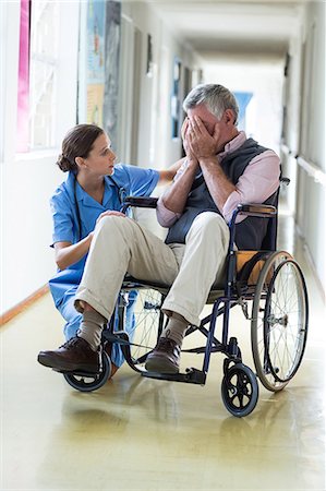 simsearch:6108-05860422,k - Female doctor consoling senior man in corridor at hospital Photographie de stock - Premium Libres de Droits, Code: 6109-08689519