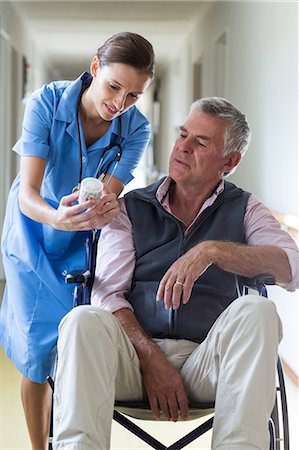 simsearch:6109-08689542,k - Female doctor giving medicine to senior man in corridor at hospital Stock Photo - Premium Royalty-Free, Code: 6109-08689520