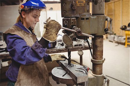 Female welder using a drill press in a workshop Foto de stock - Sin royalties Premium, Código: 6109-08689647