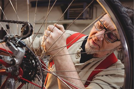 simsearch:6109-08689682,k - Bike mechanic repairing a bike in a workshop Stock Photo - Premium Royalty-Free, Code: 6109-08689654