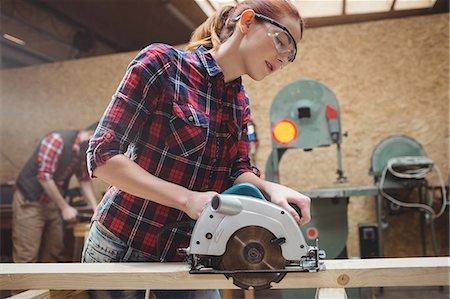 female artisan - Carpenter using a machine in carpentry Stock Photo - Premium Royalty-Free, Code: 6109-08689618