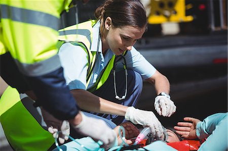 simsearch:6109-08689784,k - Ambulance crew taking care of injured woman in the street Photographie de stock - Premium Libres de Droits, Code: 6109-08689781