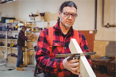 simsearch:6109-08689723,k - Carpenter looking if the wood plank is straight in his workshop Photographie de stock - Premium Libres de Droits, Code: 6109-08689707