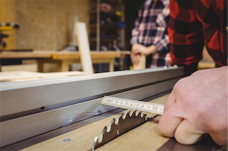 simsearch:6109-08689578,k - Carpenter measuring wood plank in workshop Foto de stock - Royalty Free Premium, Número: 6109-08689718