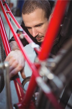 simsearch:6109-08782883,k - Mechanic repairing a bicycle in workshop Photographie de stock - Premium Libres de Droits, Code: 6109-08689840