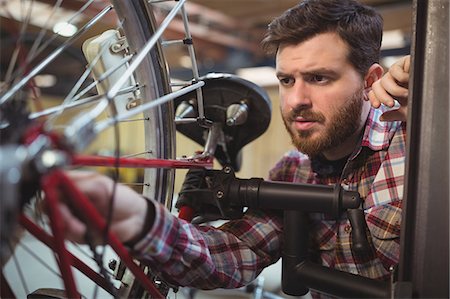 simsearch:6109-08782883,k - Mechanic repairing a bicycle in workshop Photographie de stock - Premium Libres de Droits, Code: 6109-08689853