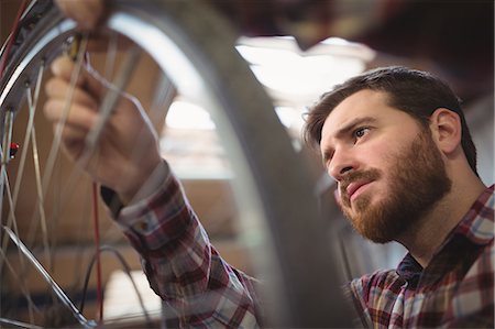 Mechanic repairing a bicycle in workshop Stock Photo - Premium Royalty-Free, Code: 6109-08689851